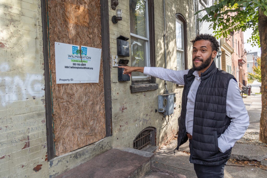 Branden Fletcher Dominguez points to an abandoned house