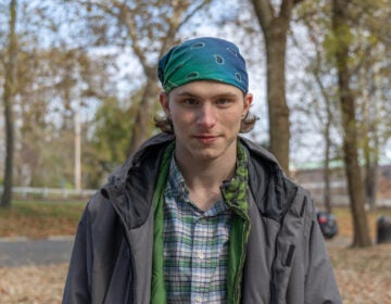 A young man poses for a photo outdoors