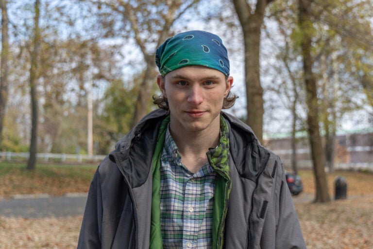 A young man poses for a photo outdoors