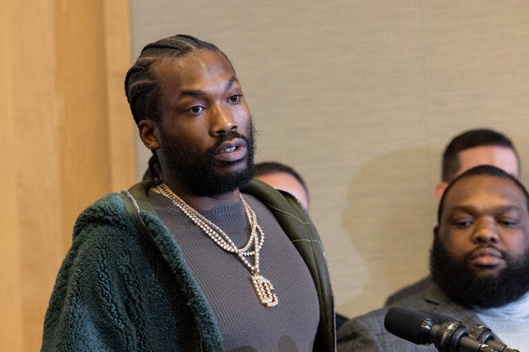 Meek Mill speaks into a microphone at a press conference