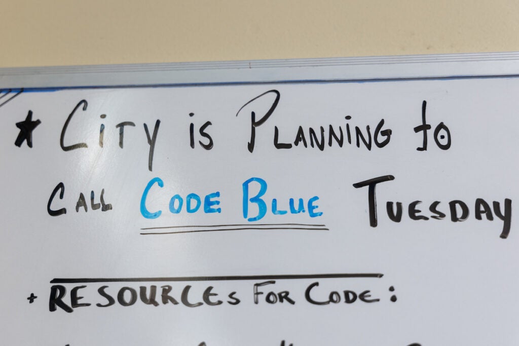 A white board reads "City is planning to call Code Blue Tuesday, Resources for code:"