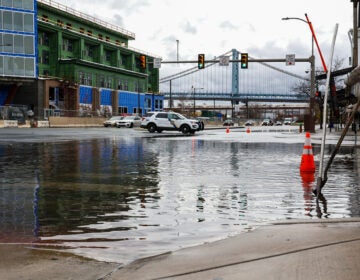 A flooded street in Philadelphia, with a bridge visible in the distance.