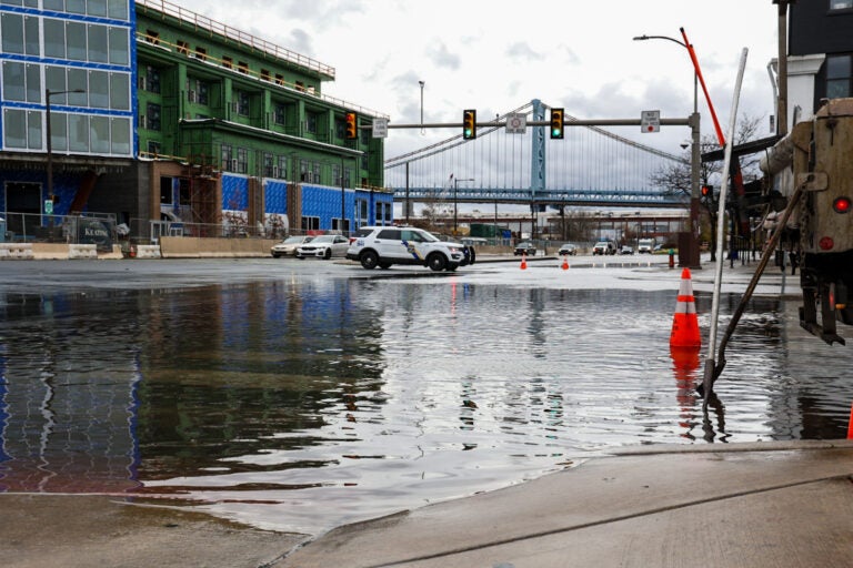 A flooded street in Philadelphia, with a bridge visible in the distance.