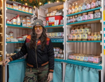 Melissa Lynn Torre, founder of the Vellum Street Soap Company, poses in front of shelves of soaps