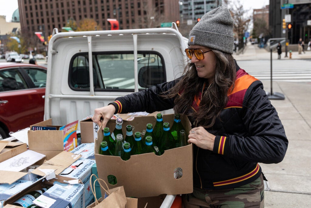 Melissa Lynn Torre lifts a box of bottles out of the back of a pick-up truck