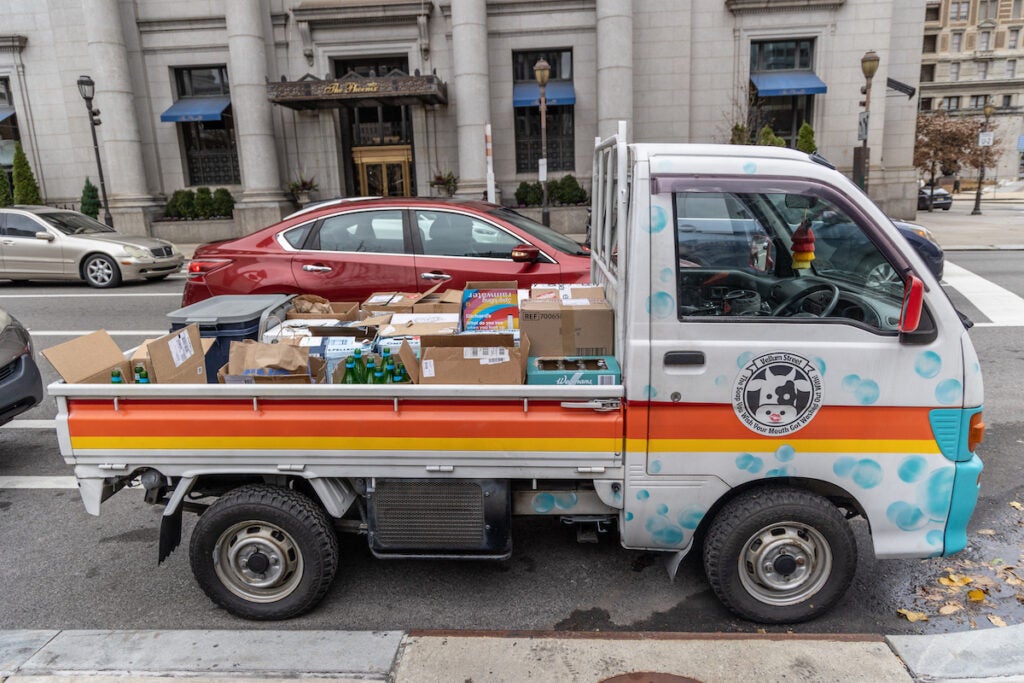 A truck bed filled with boxes is parked on the side of the road.