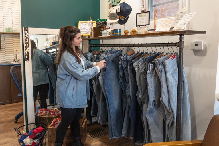 ReUp Fashion store owner Tara Martinak looks at a pair of jeans.