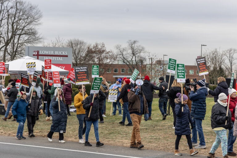 Striking nurses hold signs and march at the picket line outside of Lower Bucks Hospital