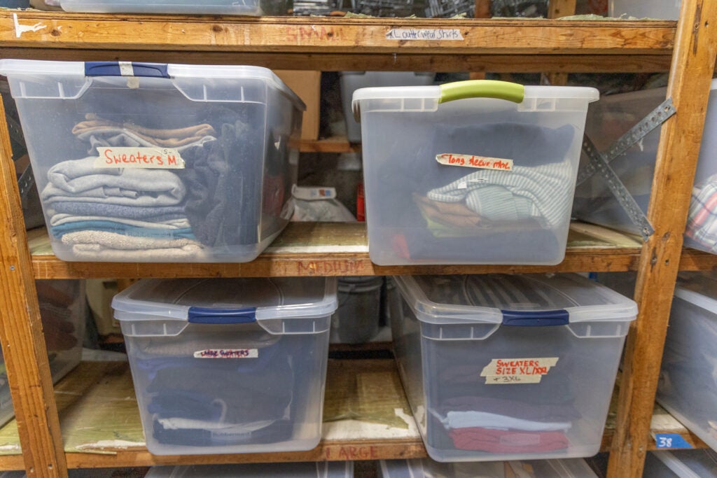 clothes sitting in bins on a shelf