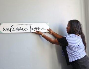 Tatyana Woodward hangs a sign up on the wall.