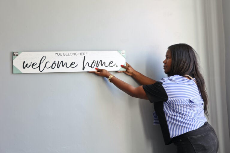 Tatyana Woodward hangs a sign up on the wall.