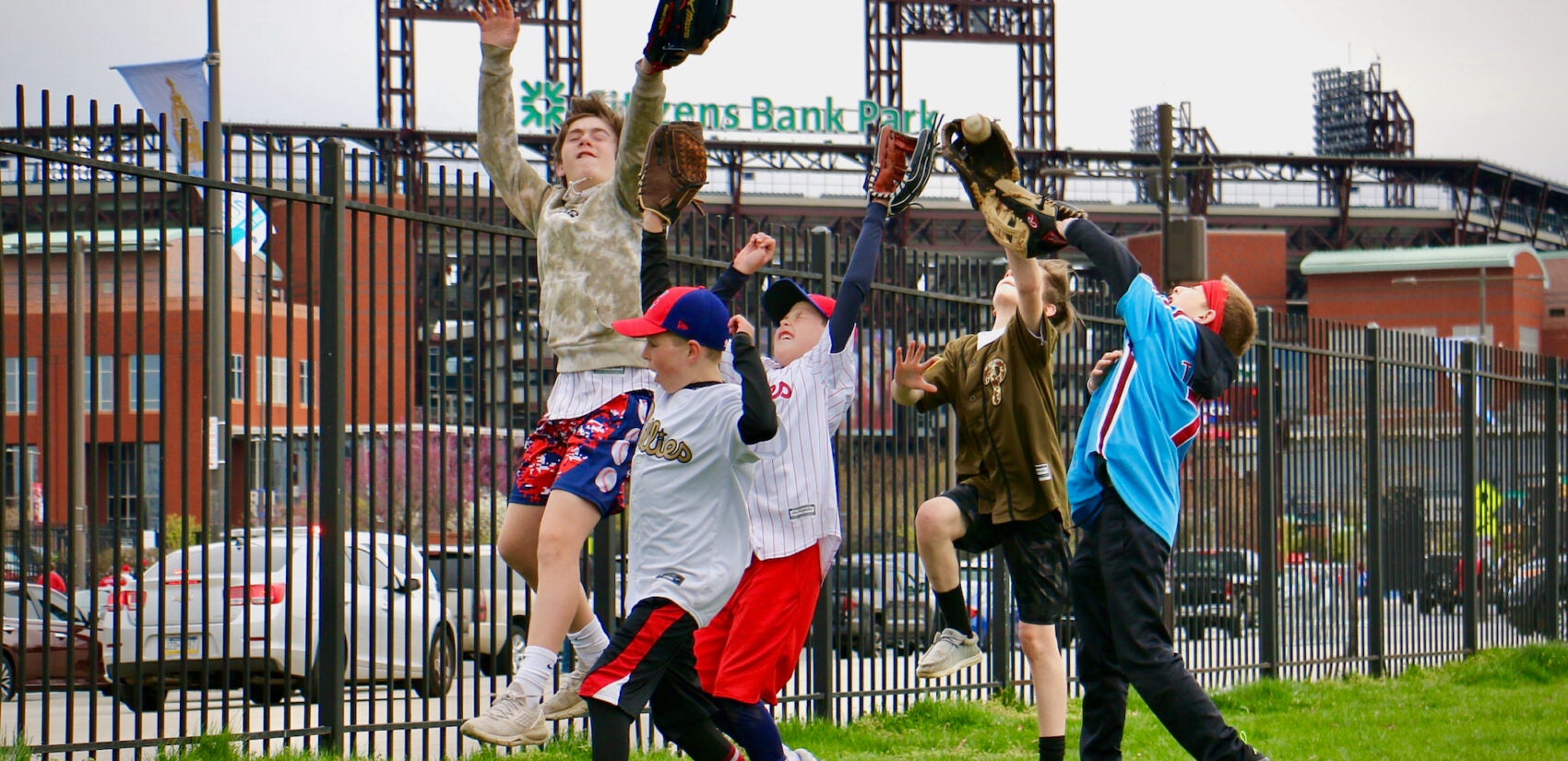 Children playing catch outside of the baseball stadium