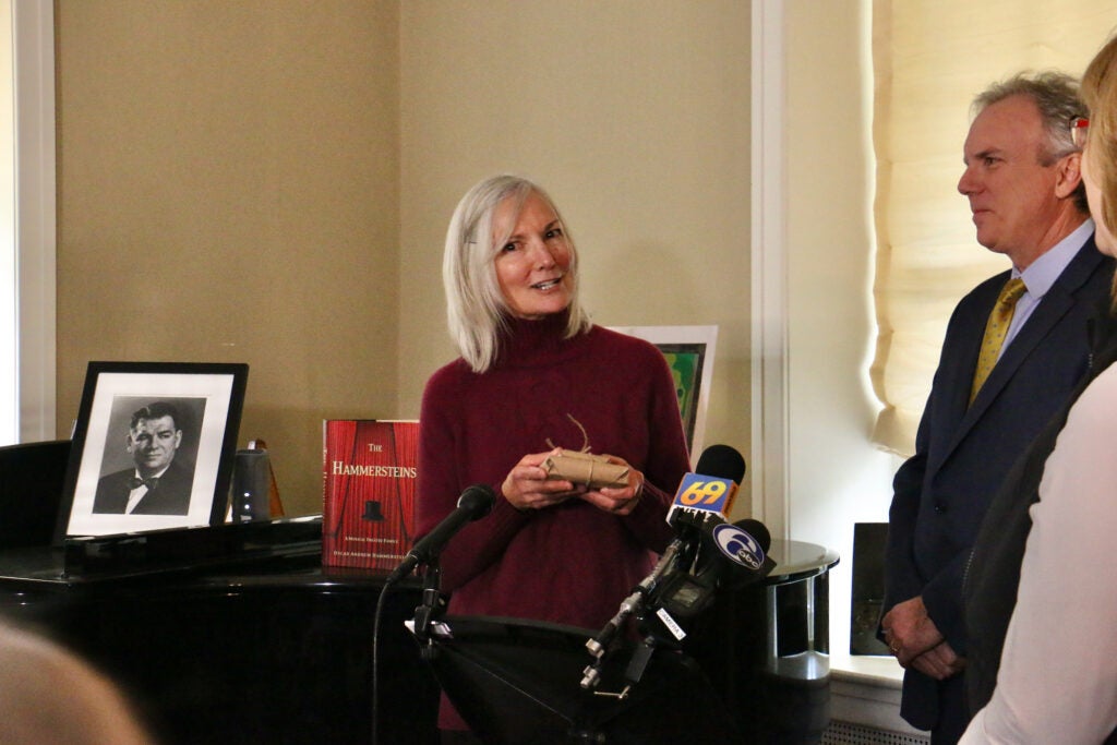 Christine Cole, who ran Highland Farm as a bed and breakfast for 16 years, presents the keys to Oscar Hammerstein's home to Greg Roth in a brown paper package tied up with string