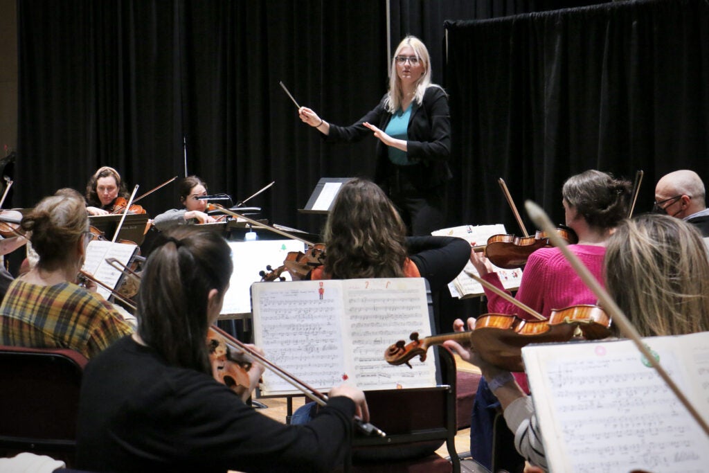 Amelia Krinke conducts an orchestra
