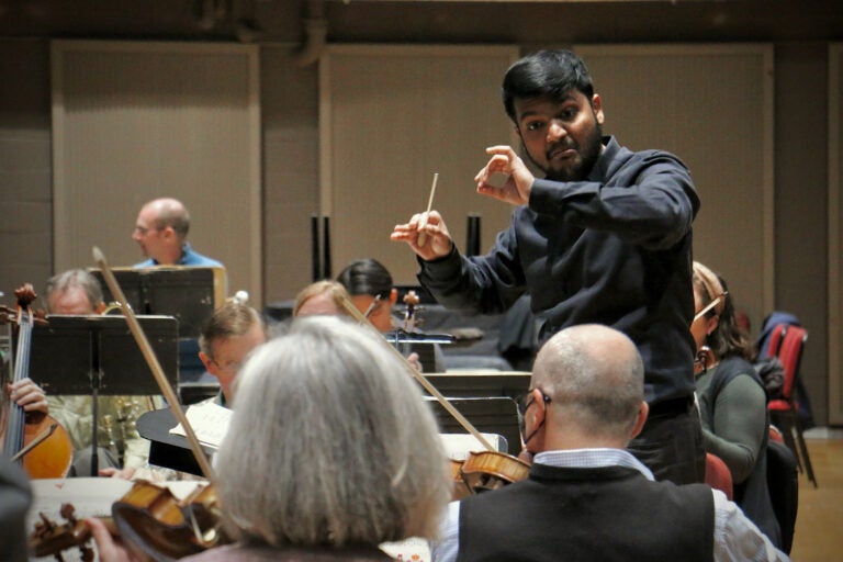 Andrew Samlal conducts the orchestra.