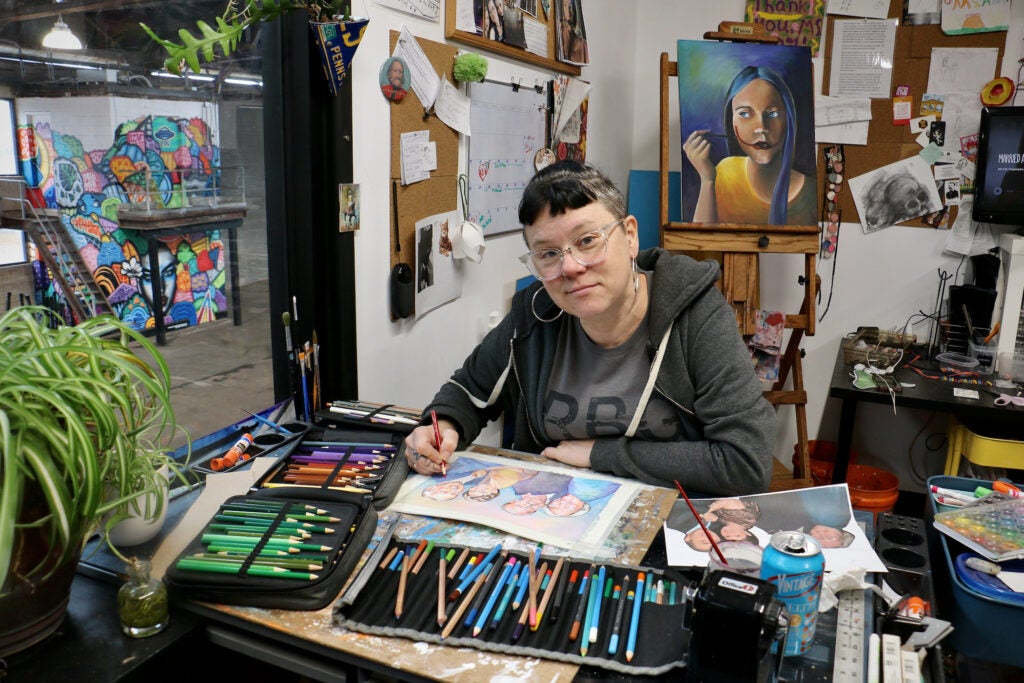 Mixed media artist Amy Kelly works on a commissioned painting in her studio