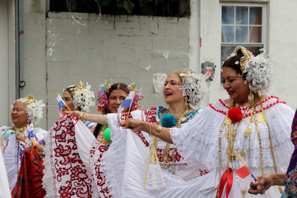 Women wearing traditional clothing sing and dance