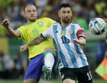 Argentina's Lionel Messi (right) and Brazil's Carlos Augusto battle for the ball during a qualifying soccer match for the FIFA World Cup 2026 at Maracana stadium in Rio de Janeiro, Brazil, Tuesday, Nov. 21, 2023