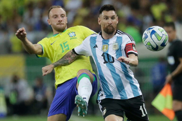 Argentina's Lionel Messi (right) and Brazil's Carlos Augusto battle for the ball during a qualifying soccer match for the FIFA World Cup 2026 at Maracana stadium in Rio de Janeiro, Brazil, Tuesday, Nov. 21, 2023