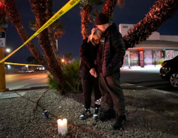 Sean Hathcock, right, kisses Michelle Ashley after the two left candles for victims of a shooting at the University of Nevada, Las Vegas, Wednesday, Dec. 6, 2023, in Las Vegas. The two graduated from the school and live nearby. (AP Photo/John Locher)