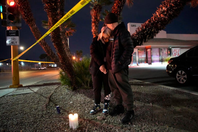 Sean Hathcock, right, kisses Michelle Ashley after the two left candles for victims of a shooting at the University of Nevada, Las Vegas, Wednesday, Dec. 6, 2023, in Las Vegas. The two graduated from the school and live nearby. (AP Photo/John Locher)