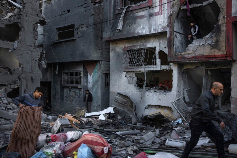 Palestinians look at houses destroyed in the Israeli bombardment of the Gaza Strip in Rafah on Saturday, Dec. 9, 2023.
