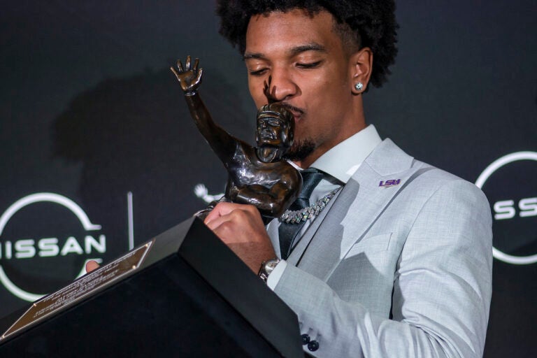 LSU quarterback Jayden Daniels kisses the Heisman Trophy during a news conference after winning the award Saturday, Dec. 9, 2023, in New York.