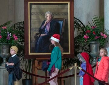 Children pass by the portait of Sandra Day O'Connor as mourners pay their respects as the flag-draped casket of retired Supreme Court Justice Sandra Day O'Connor lies in the Great Hall at the Supreme Court in Washington, Monday, Dec. 18, 2023. O'Connor, an Arizona native and the first woman to serve on the nation's highest court, died Dec. 1 at age 93.