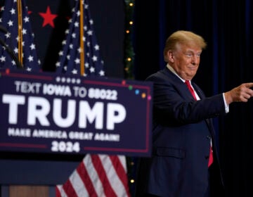 Trump greets supports next to a podium.