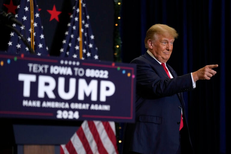 Trump greets supports next to a podium.