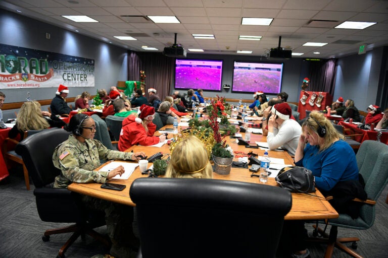 This image provided by the Department of Defense shows volunteers answering phones and emails from children around the globe during the annual NORAD Tracks Santa event on Peterson Air Force Base in Colorado Springs, Colo., Dec. 24, 2022.