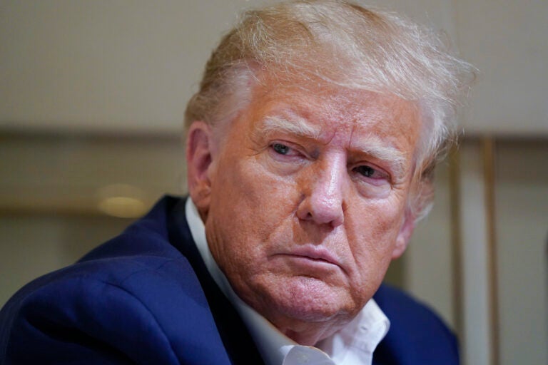 File photo: Former President Donald Trump listens as he speaks with reporters while in flight on his plane after a campaign rally at Waco Regional Airport, in Waco, Texas, March 25, 2023, while en route to West Palm Beach, Fla.