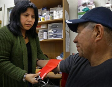 Laura Lopez, left, checks the blood pressure of Santos Aguilar at the Street Level Health Project in Oakland, Calif. (AP file Photo/Ben Margot)
