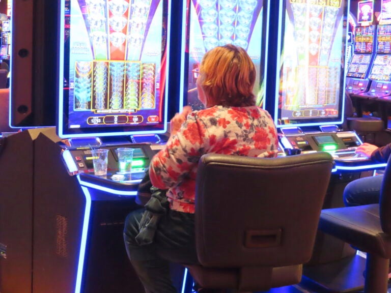 person smoking while playing a slot machine