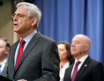 Attorney General Merrick Garland speaks with reporters during a news conference at the Department of Justice on Wednesday as Secretary of Homeland Security Alejandro Mayorkas, right, looks on. Mark Schiefelbein/AP