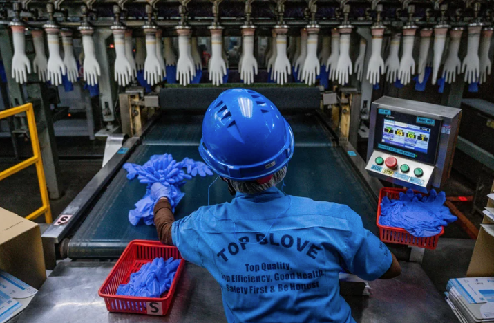 A worker inspects disposable gloves
