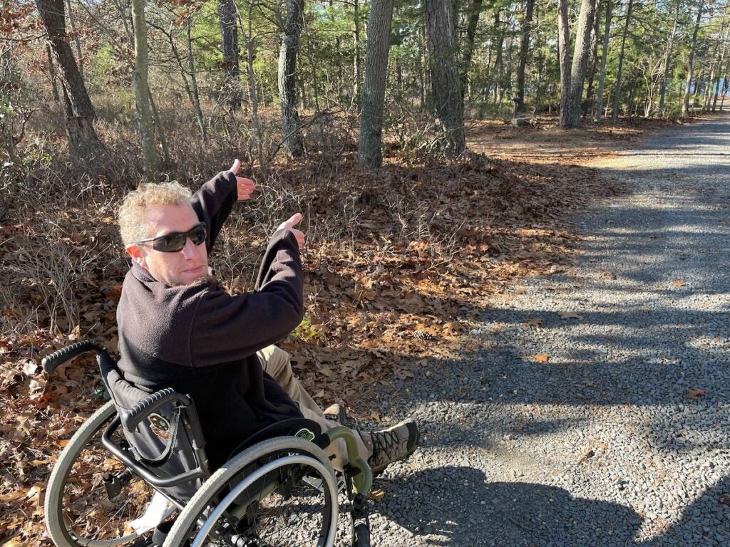 Sean Holland, the Access Nature Disability Advocate for the Pinelands Preservation Alliance, points towards improvements that are being made on a wooded path