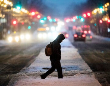 A person crosses South Broad Street during a winter storm in Philadelphia