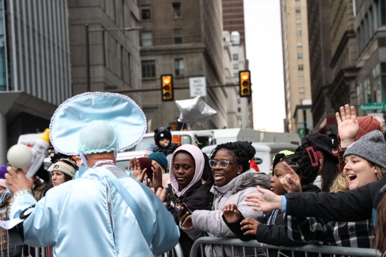 Spectators reach out to a performer during the Mummers Parade