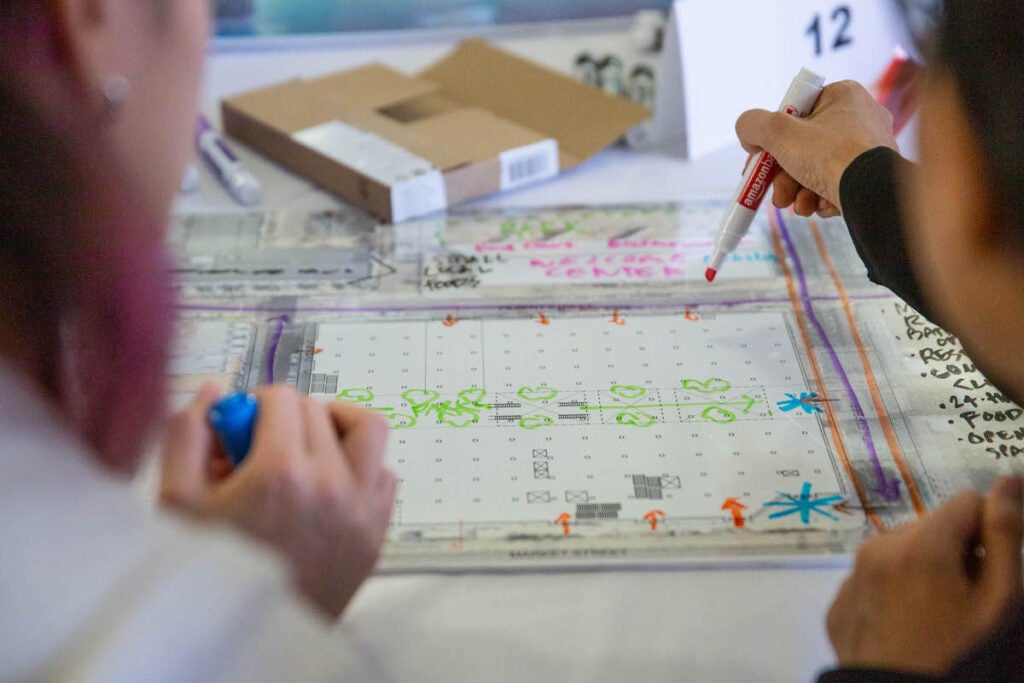 A close-up of people drawing on a design grid