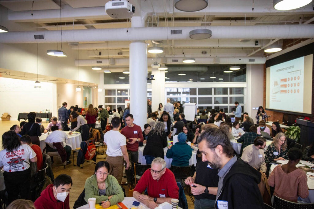 A view of more than 100 people seated at tables in a room