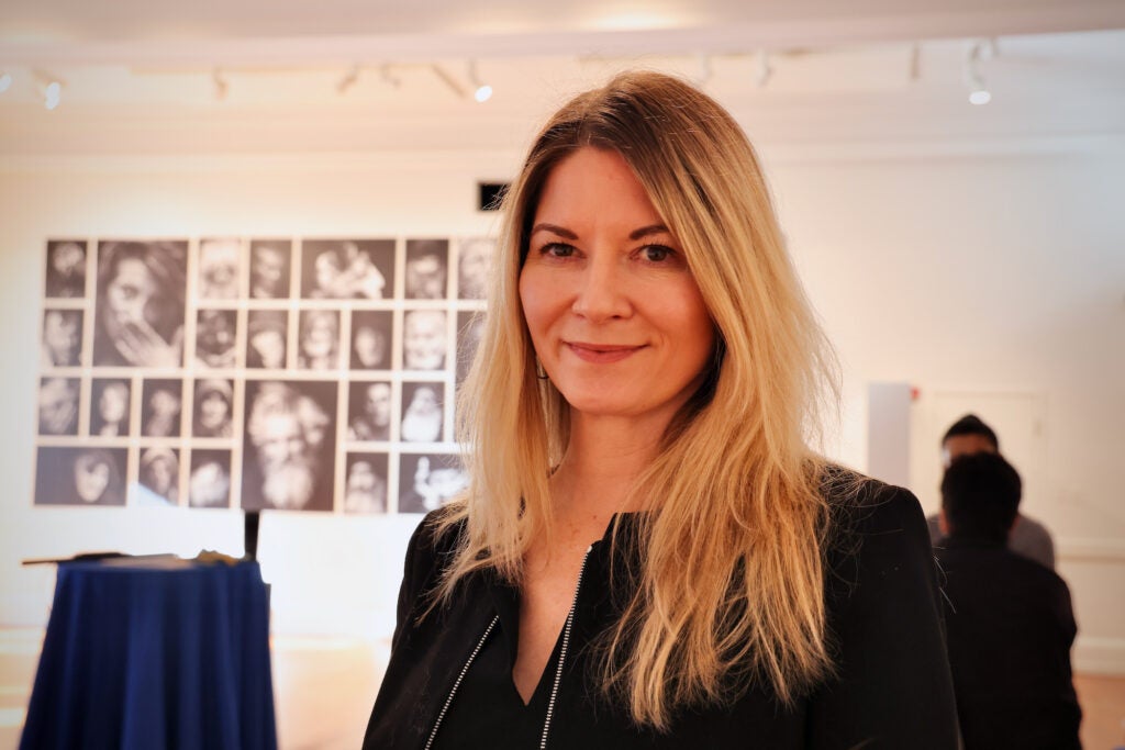 Kate Quinn poses for a photo in front of an exhibit