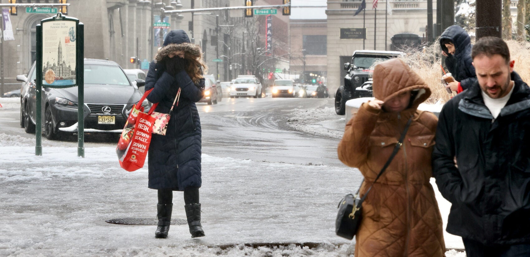 Pedestrians in Philadelphia struggling to walk on sidewalks coated with ice and snow.
