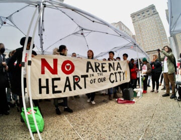 People hold up a sign that reads 