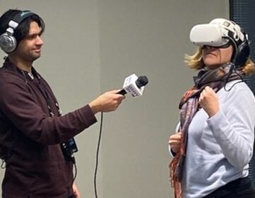 Reporter Grant Hill (left) and host
Maiken Scott of WHYY’s “The Pulse” interact with virtual reality headsets and headphones showing a quintet playing Mozart.  (Alexis Branagan, Princeton University Concerts)