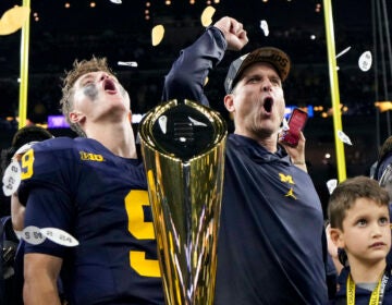 Michigan head coach Jim Harbaugh and quarterback J.J. McCarthy celebrate with the trophy after their win against Washington in the national championship NCAA College Football Playoff game Monday, Jan. 8, 2024, in Houston.