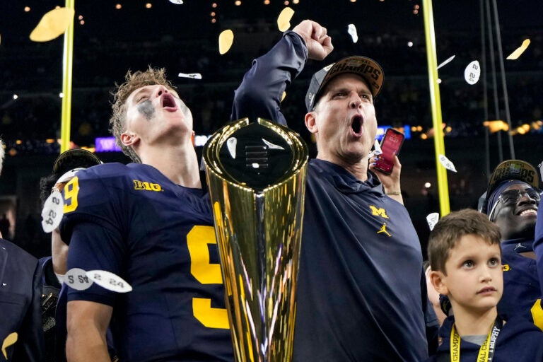 Michigan head coach Jim Harbaugh and quarterback J.J. McCarthy celebrate with the trophy after their win against Washington in the national championship NCAA College Football Playoff game Monday, Jan. 8, 2024, in Houston.