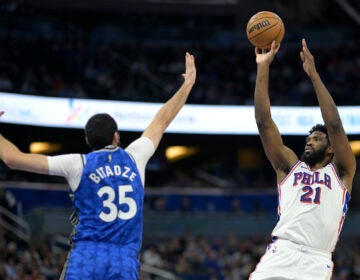 Philadelphia 76ers center Joel Embiid (21) shoots in front of Orlando Magic center Goga Bitadze (35) during the first half of an NBA basketball game, Friday, Jan. 19, 2024, in Orlando, Fla. (AP Photo/Phelan M. Ebenhack)