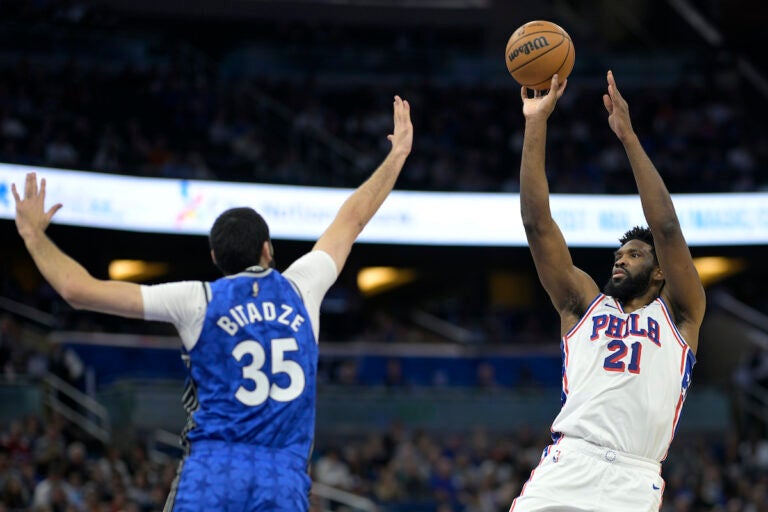 Philadelphia 76ers center Joel Embiid (21) shoots in front of Orlando Magic center Goga Bitadze (35) during the first half of an NBA basketball game, Friday, Jan. 19, 2024, in Orlando, Fla. (AP Photo/Phelan M. Ebenhack)