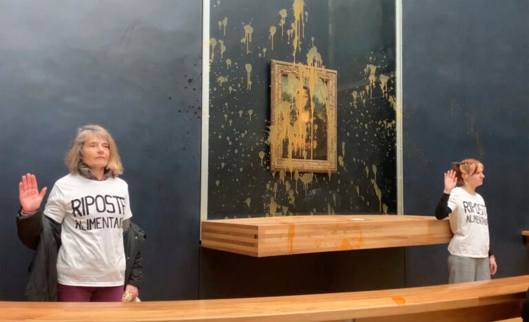 In this grab taken from video, activists gesture after throwing soup at the glass protecting the Mona Lisa, at the Louvre Museum, in Paris, Sunday. Jan. 28, 2024, shouting slogans advocating for a sustainable food system.